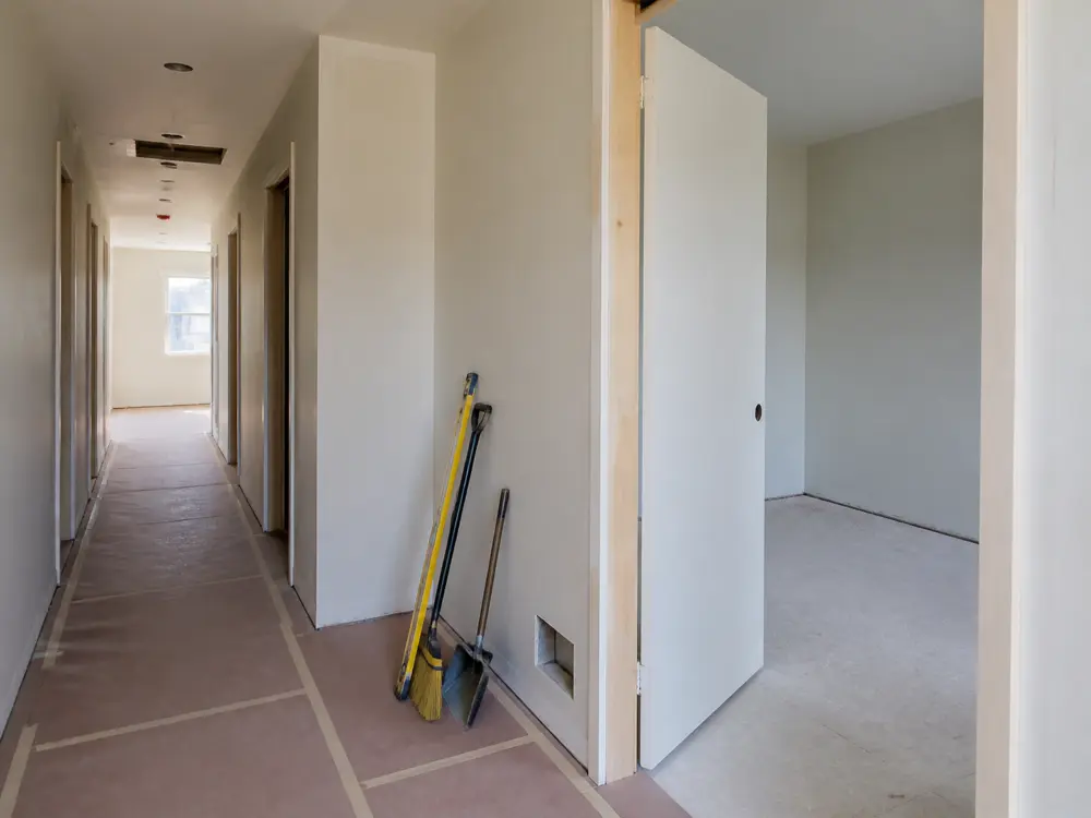 A rental interior between tenancies, cleared and prepared for repair and repainting.