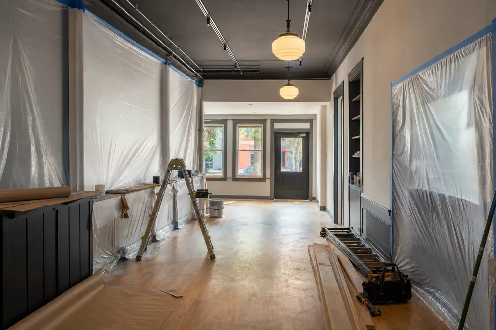 A small commercial interior keeps a clear operating path beside a cleanly contained renewal area.