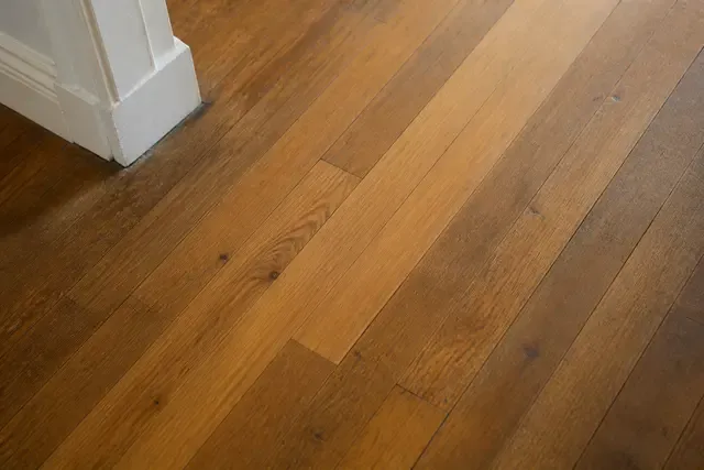 Repaired wood boards meet an existing floor with a restrained difference in age and patina.